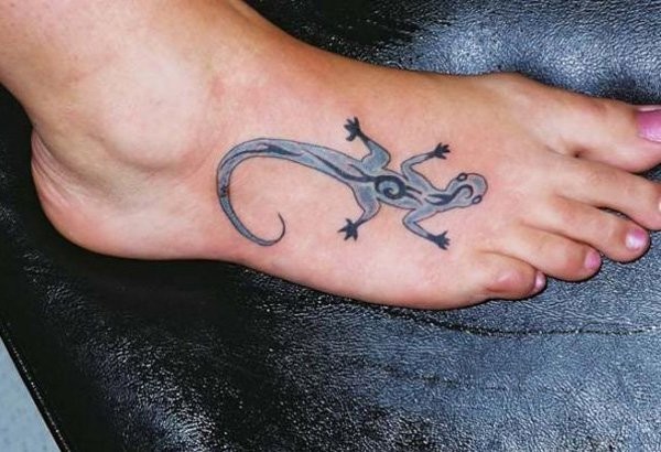 Small black ink funny lizard tattoo on foot stylized with tribal ornaments