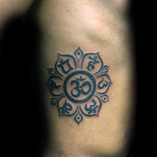 Small black ink side tattoo of small Hinduism themed flower
