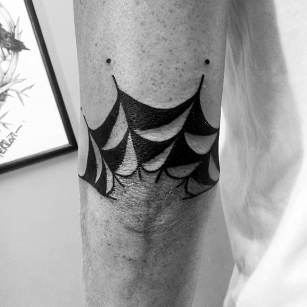 Small black ink spider web like tattoo on elbow