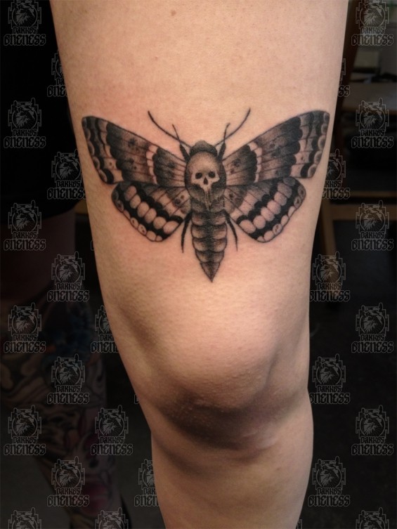 Small black ink thigh tattoo of butterfly with human skull