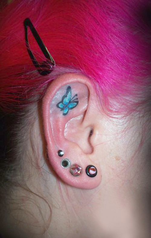 Small blue butterfly tattoo on ear