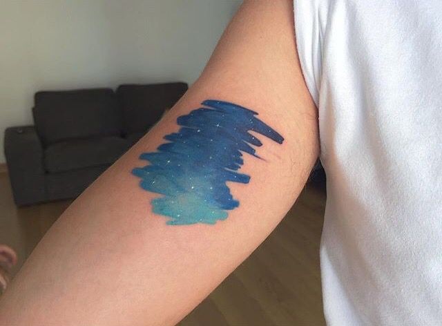 Small blue colored arm tattoo of night sky