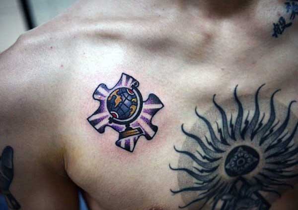 Small cartoon style colored chest tattoo of puzzle piece stylized with small globe