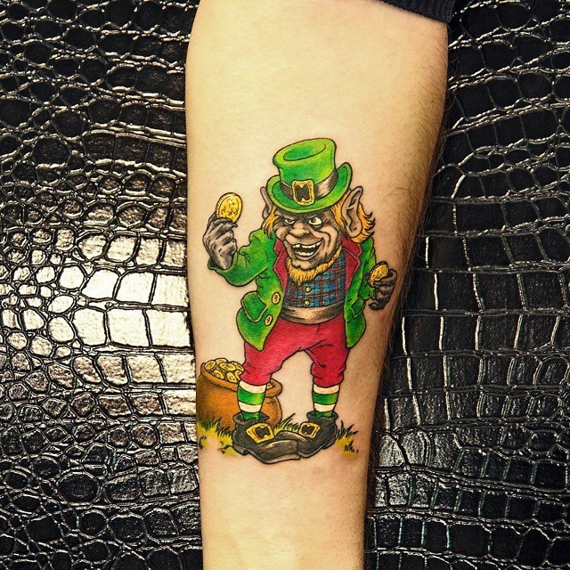 Small cartoon style colored forearm tattoo of leprechaun with golden coins