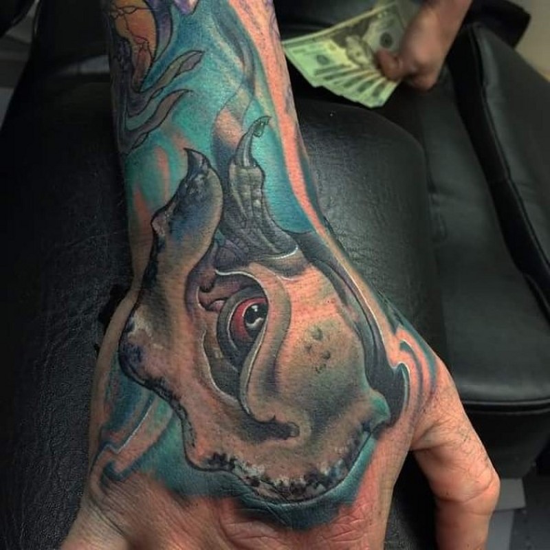 Small cartoon style colored underwater monster head tattoo on hand and wrist
