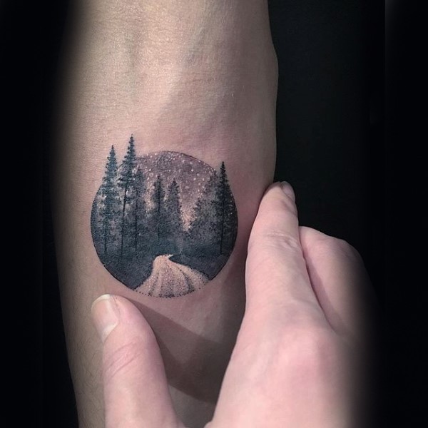 Small circle shaped stippling style tattoo of night forest road