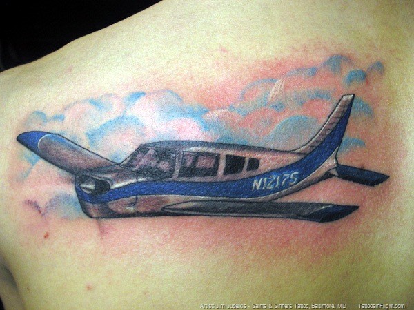 Small colored scapular tattoo of flying plane