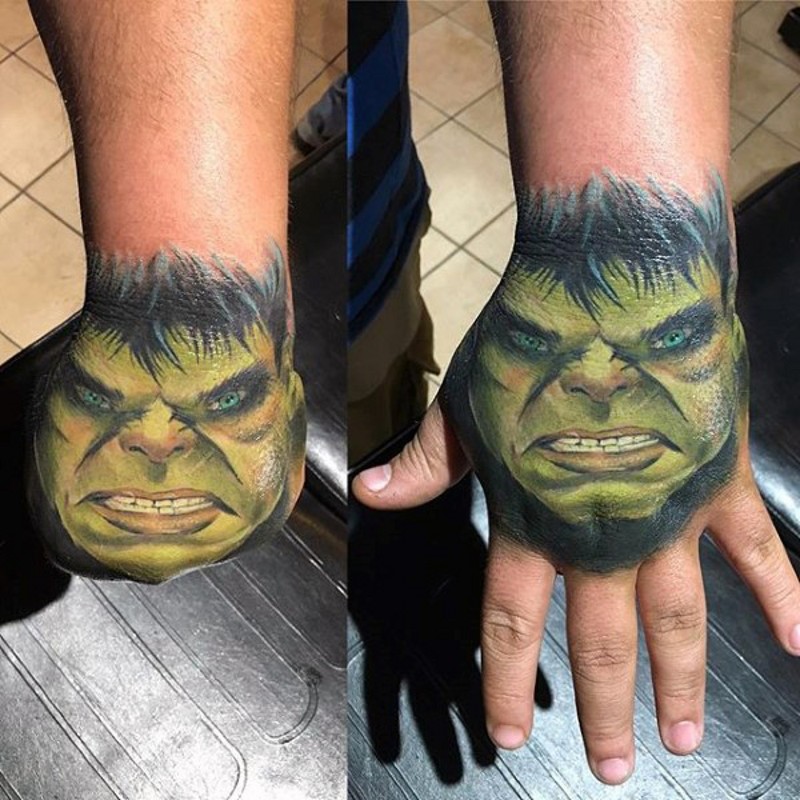 Small colored usual Hulk face tattoo on hand
