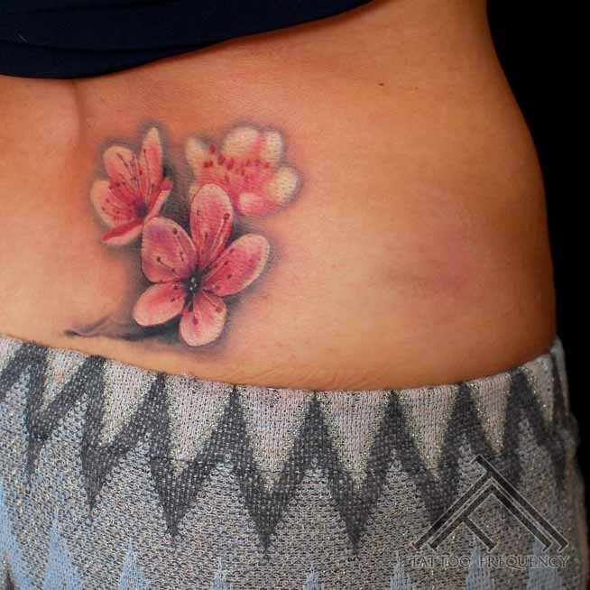 Small colored waist tattoo of small sweet flowers