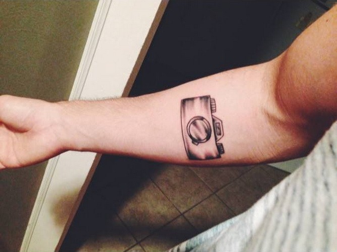 Small cool gray-ink camera tattoos on forearm