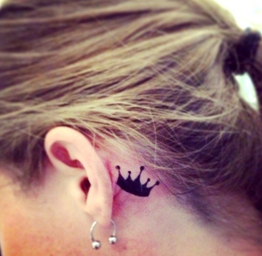 Small crown behind the ear tattoo