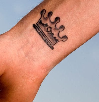 Small crown on wrist tattoo
