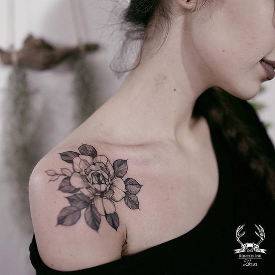 Small cute looking by Zihwa tattoo on shoulder of rose