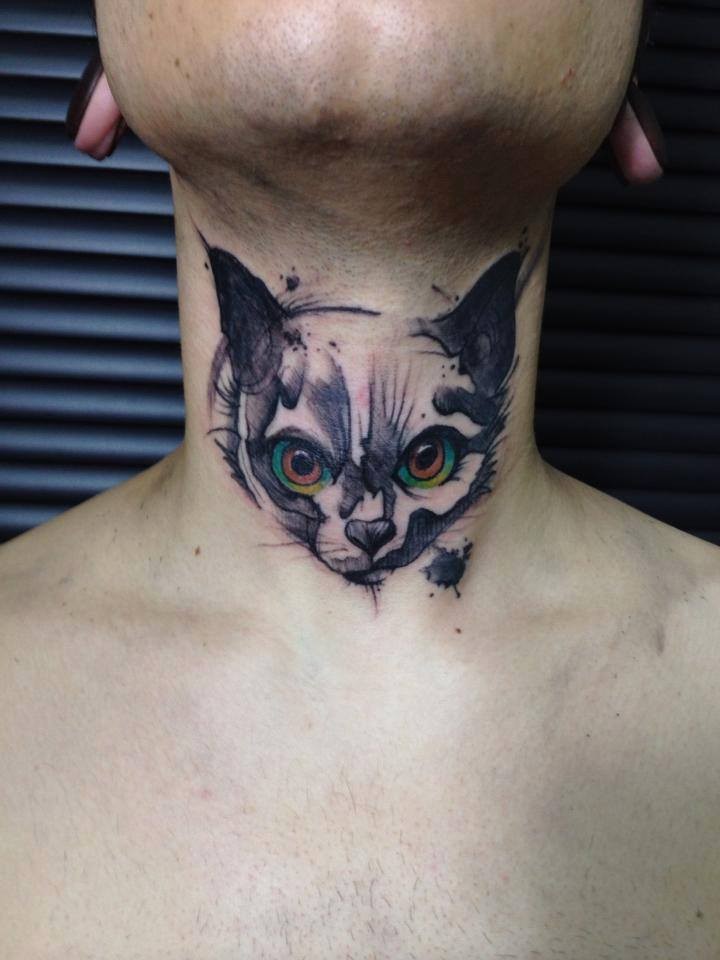 Small cute looking neck tattoo of evil face