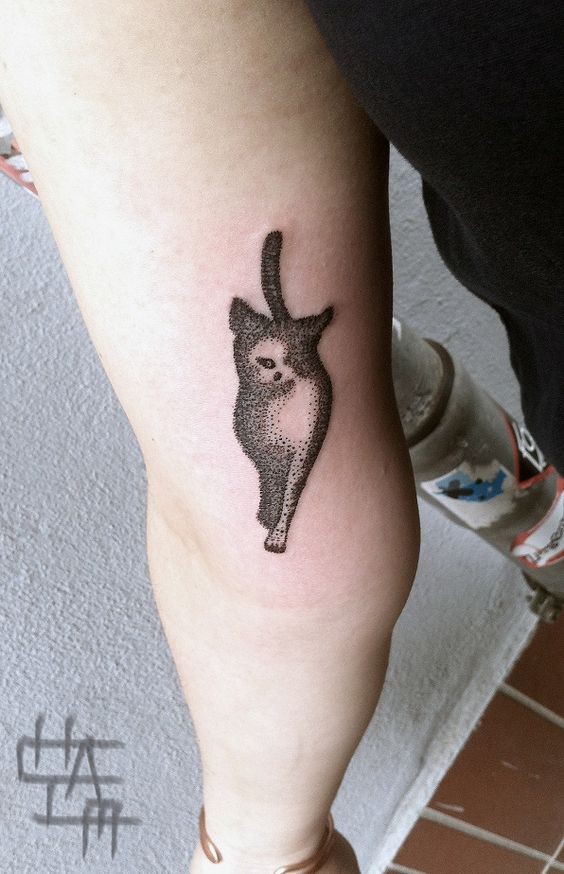 Small dot style leg tattoo of walking cat