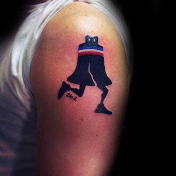 Small funny looking bell with legs tattoo on upper arm
