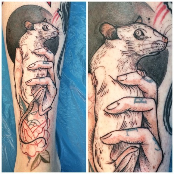 Small illustrative style leg tattoo of hand holding rat