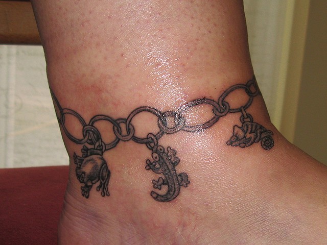 Tatuaje de cadena con animales en el tobillo