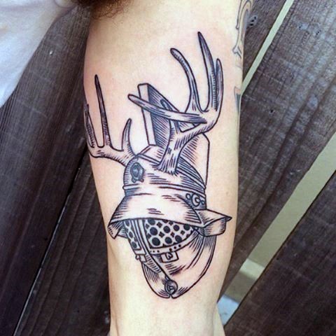 Small interesting looking engraving style biceps tattoo of old gladiators helmet stylized with deer horns