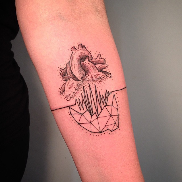 Small mystical looking forearm tattoo of human heart