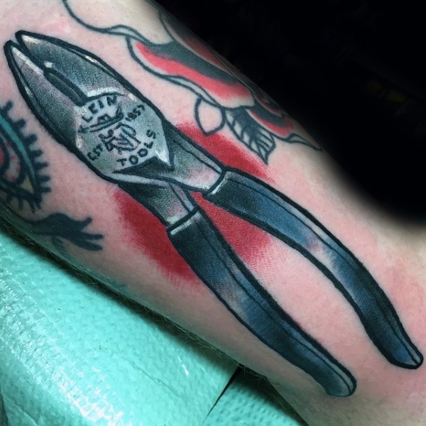 Small nice looking lineman tools tattoo on arm