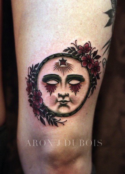 Small old school style tattoo of fantasy face with flowers