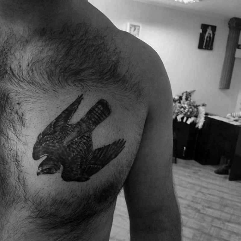 Small real photo style black ink chest tattoo of flying eagle