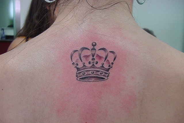 Small realistic crown tattoo on upper back