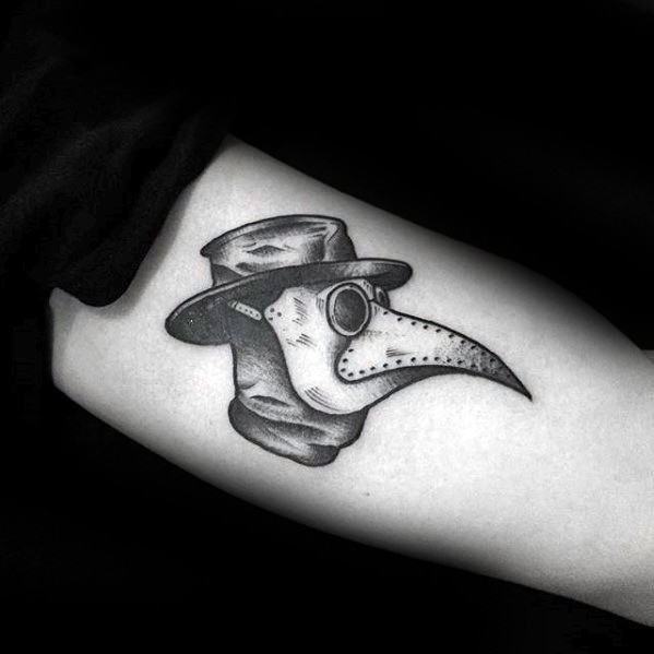 Small simple looking arm tattoo of plague doctors head