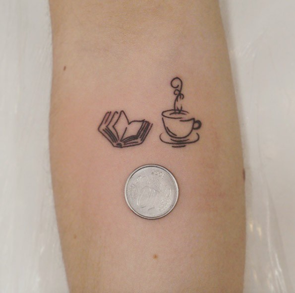 Tatuaje en el antebrazo,
libro abierto y taza de té diminutos