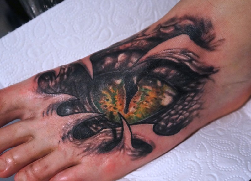Tatuaje en el pie, ojo de serpiente con piel rasgada