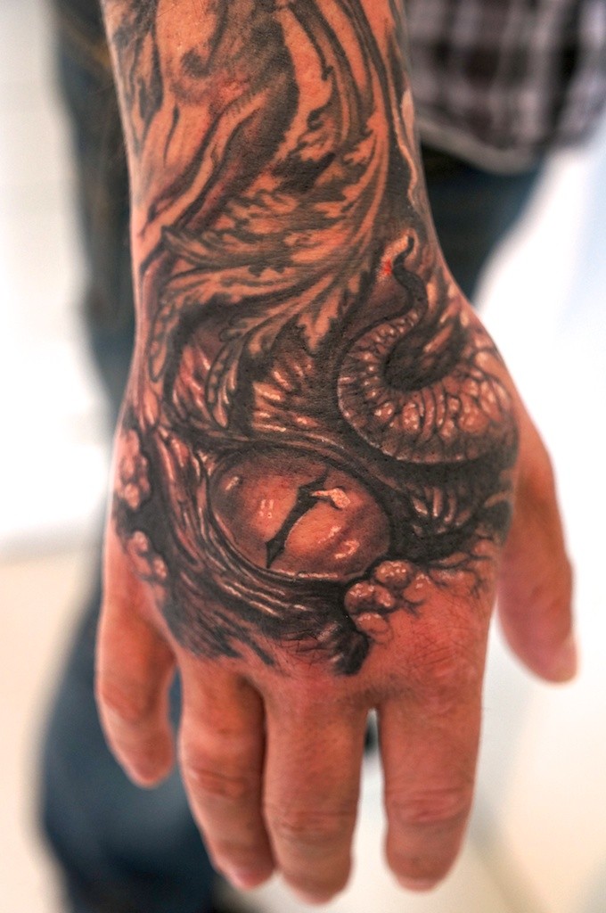 Tatuaggio sulla mano il nido dei serpenti con gli uova di serpenti