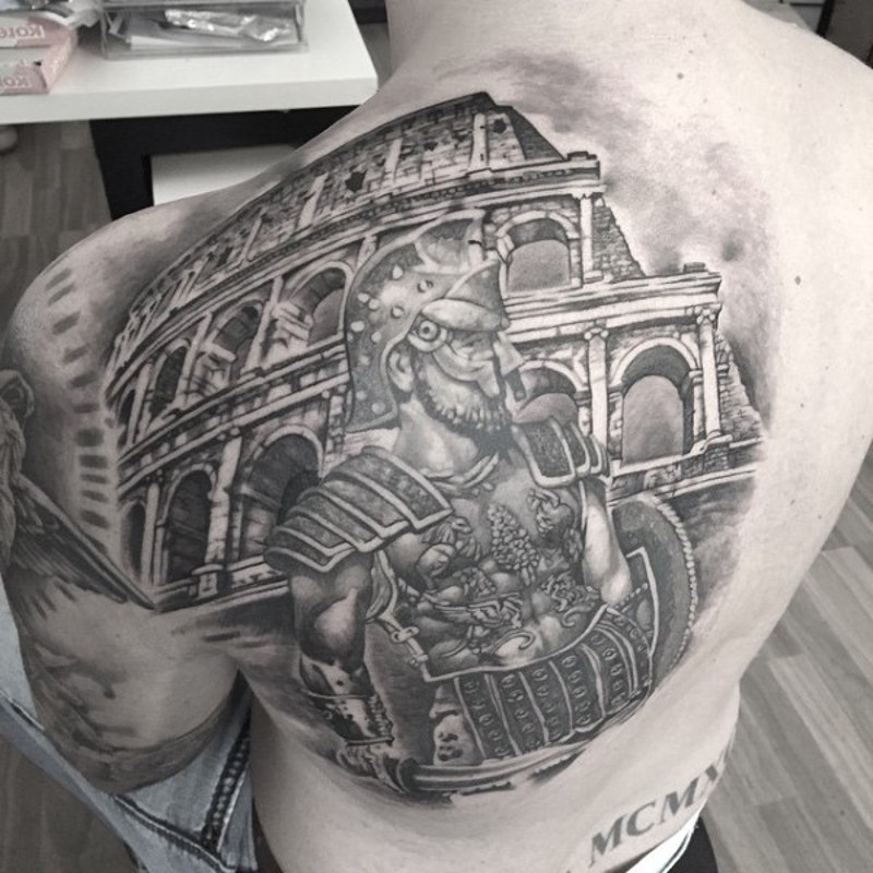 Spectacular black ink detailed looking gladiator tattoo on back combined with ancient Roman arena