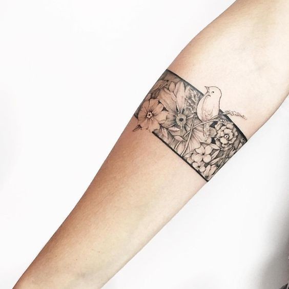 Spektakuläre schwarze Tinte Unterarm Tattoo von verschiedenen Blumen mit kleinen Vogel