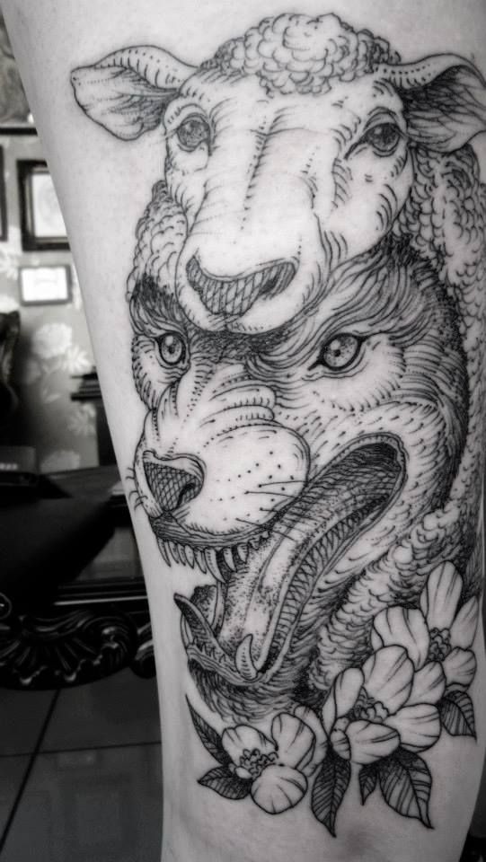 Spectacular black ink wolf in sheep's clothing tattoo stylized with flowers