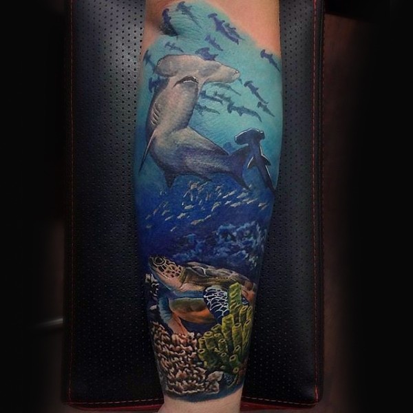 Spectacular colored forearm tattoo of underwater sharks and turtle
