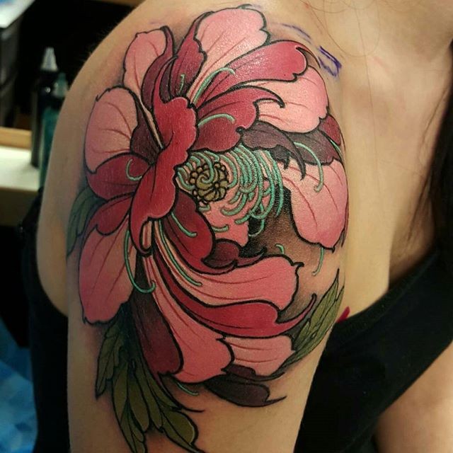 Spectacular looking colored shoulder tattoo of large flower