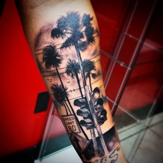 Spectacular looking very detailed arm tattoo of palm tree with road sign