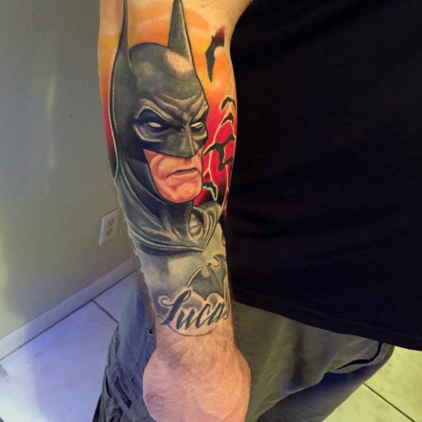 Spectacular multicolored forearm tattoo of Batman with lettering