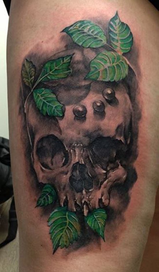 Spectacular realism style colored thigh tattoo of human skull with leaves