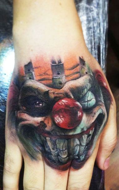 Spooky clown with red nose tattoo on hand