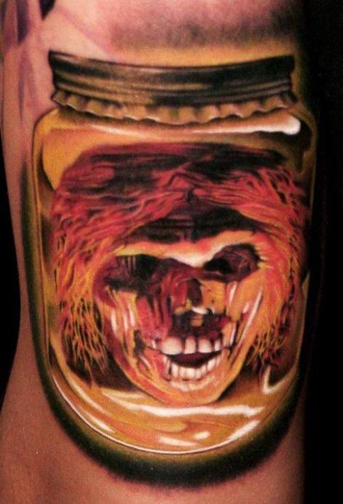 Spooky demon head in a glass jar tattoo