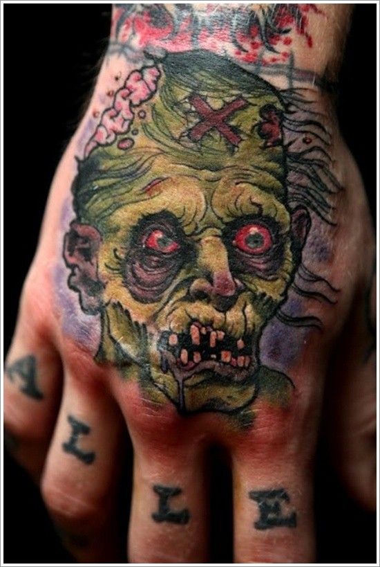 Tattoo von schrecklichem grünem Zombie an der Hand