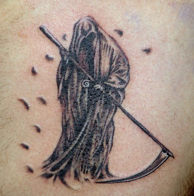 Spooky grim reaper with scythe tattoo