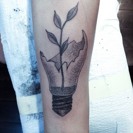 Stippling style black ink arm tattoo of broken bulb with plant
