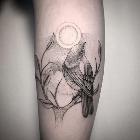 Stippling style black ink arm tattoo of small bird sitting on tree branch