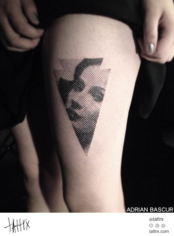 Stippling style black ink arrow head shaped thigh tattoo stylized with woman portrait