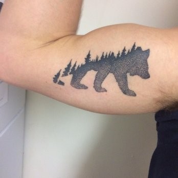Stippling style black ink biceps tattoo of bear stylized with forest