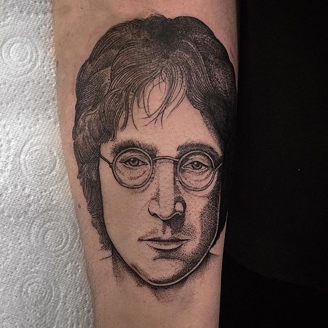 Stippling style black ink forearm tattoo of Lennon portrait
