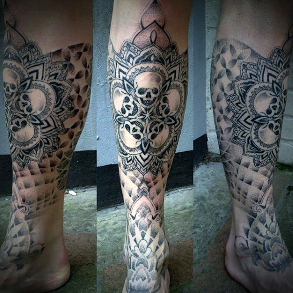 Stippling style black ink leg tattoo of various skulls and flowers